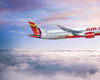 Air India airplane in flight, cruising over a sea of white clouds with a serene sky tinged in pink and blue hues. The aircraft’s red-and-orange tail and engine accents stand out against the pale sky.